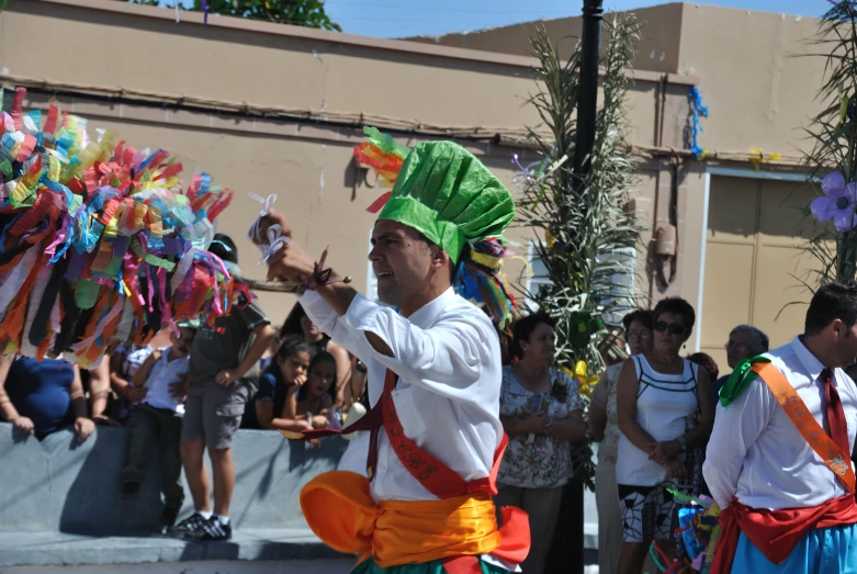 a man in an elaborately dressed costume walking through a crowd