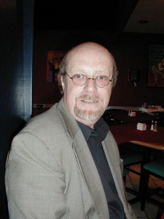 a man wearing a plaid jacket and tie in a restaurant