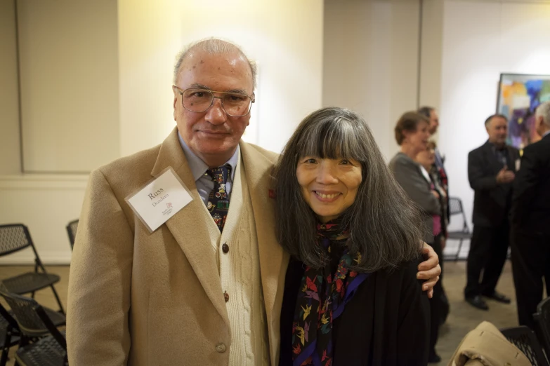 a man and woman standing next to each other at a social event