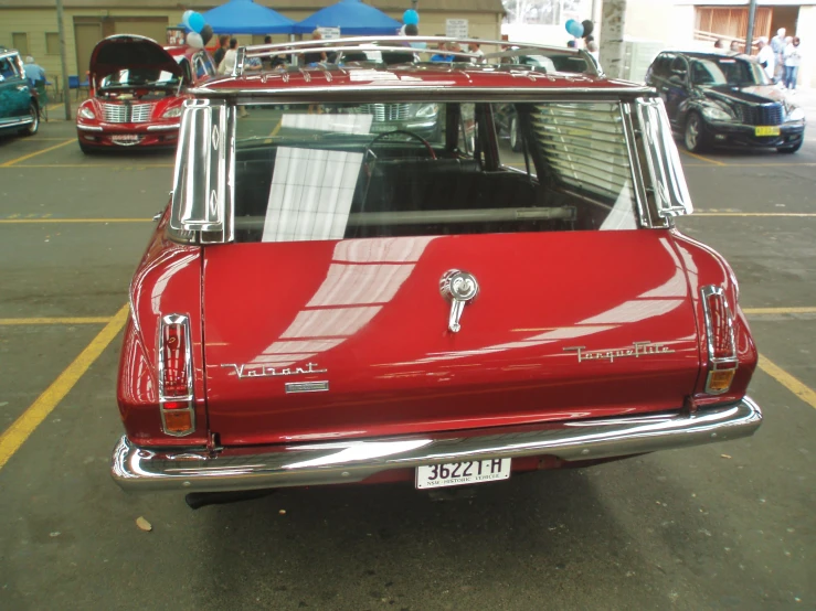 a red classic car in a parking lot