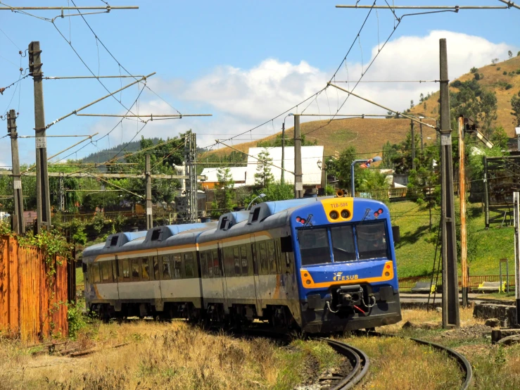 an electric train driving along tracks in the countryside