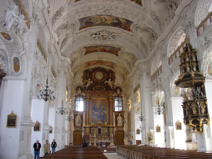 people are standing in an old church with chandeliers