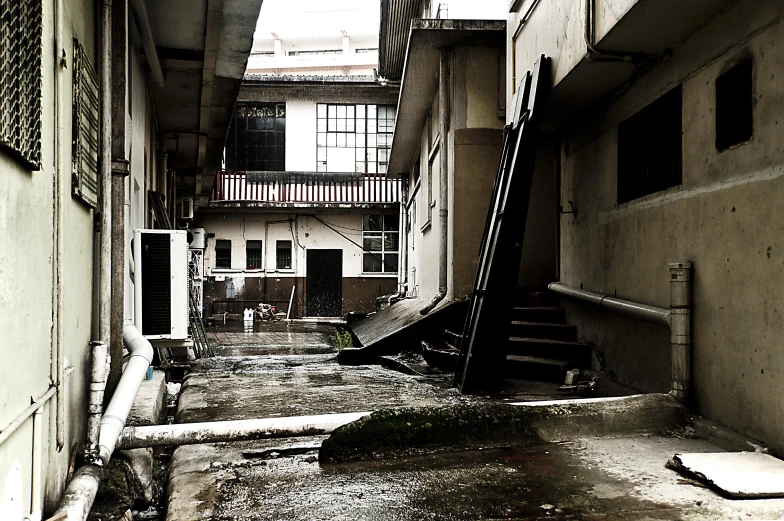 a dilapidated city street has old stairs and a broken ladder