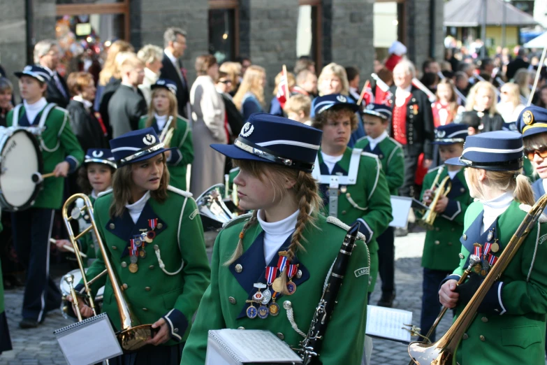 people are dressed in green uniforms and marching equipment