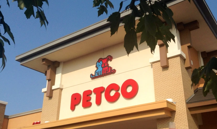 close up of petco store building sign with trees in front