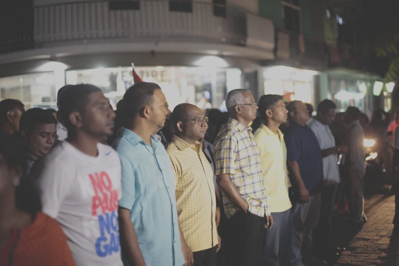 many people standing side by side in a line at night