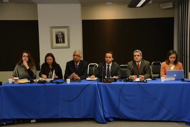 several people are at a table in front of the camera