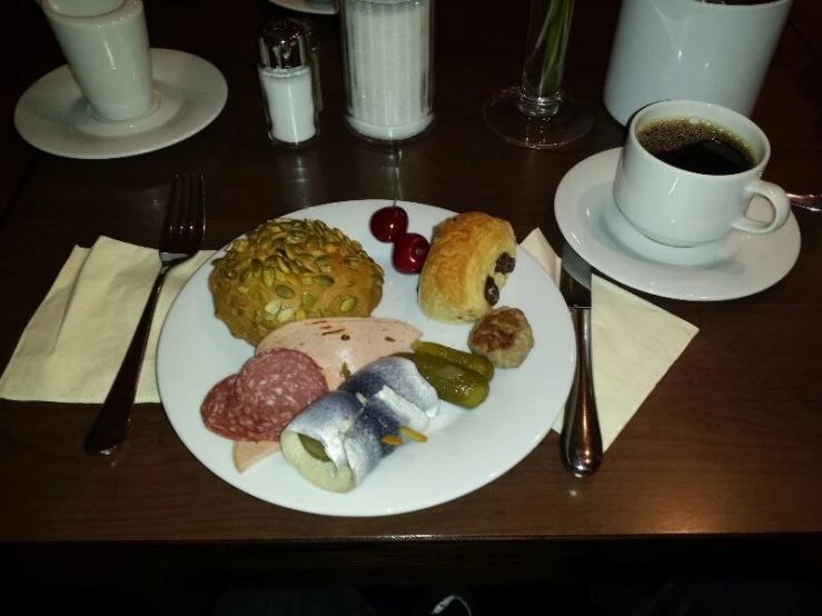 a plate with assorted meats and pastries on it