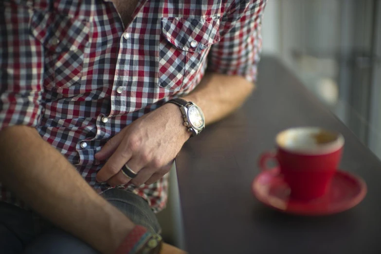 the man is sitting near the red cup