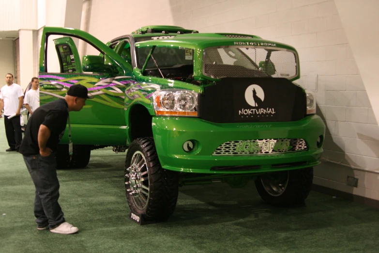 a man standing in front of a green truck