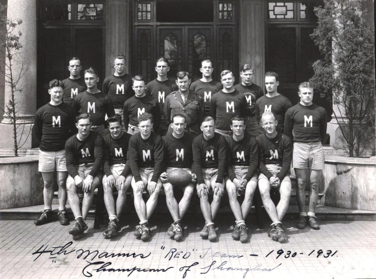 a black and white po of men posing for a team po