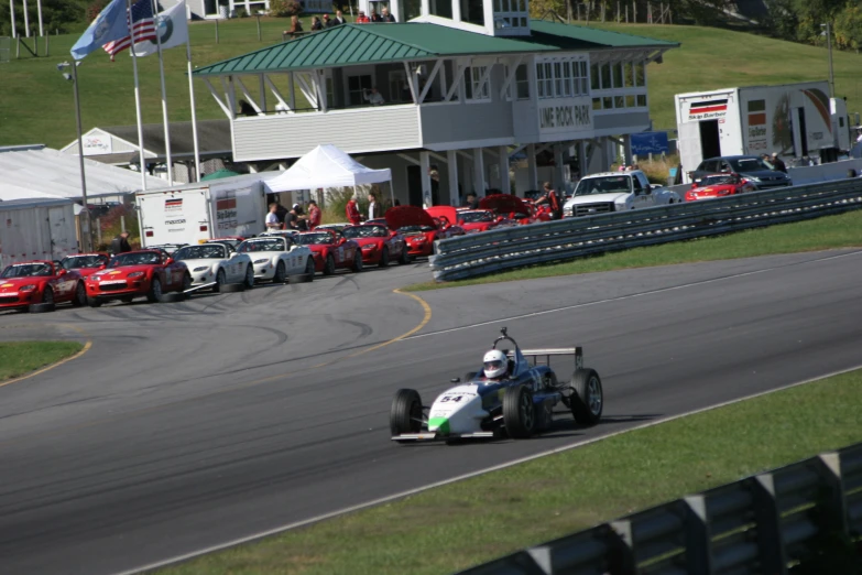 a man is racing a car near some race cars