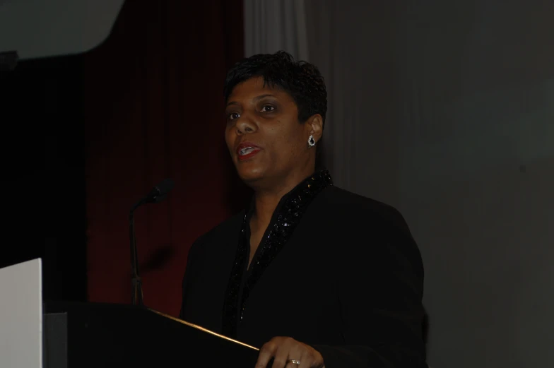 a woman is speaking at a podium