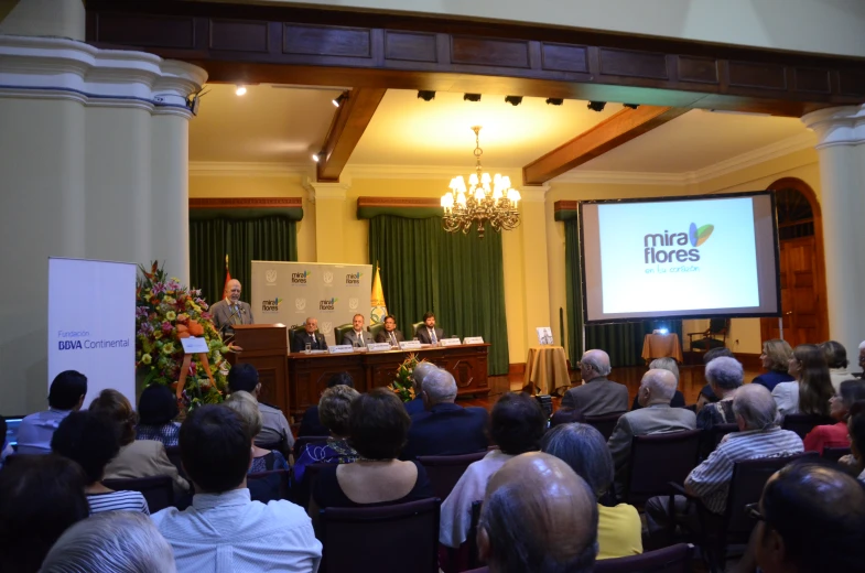 people in chairs watching a panel on health and aging