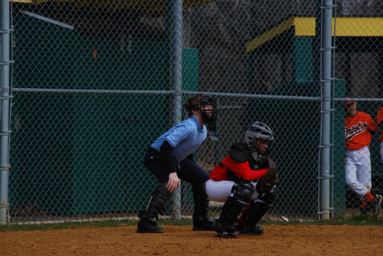 a little league baseball game as the batter holds out his glove to catch the ball