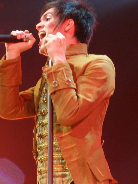 a man holding a microphone on stage with both hands