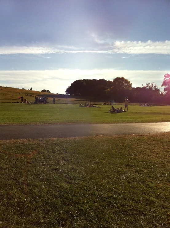 a large field with people on a grassy hill