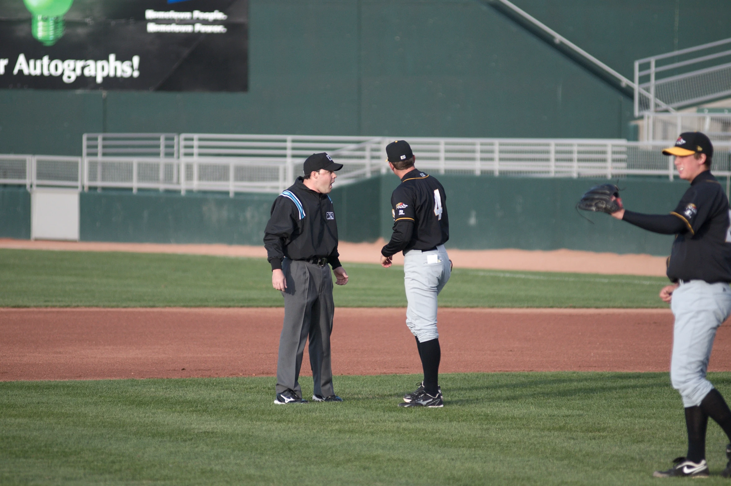 three baseball players standing on a field during a game