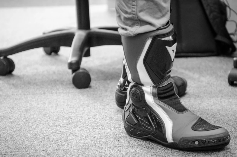 a close up of the foot of a person wearing black and white shoes