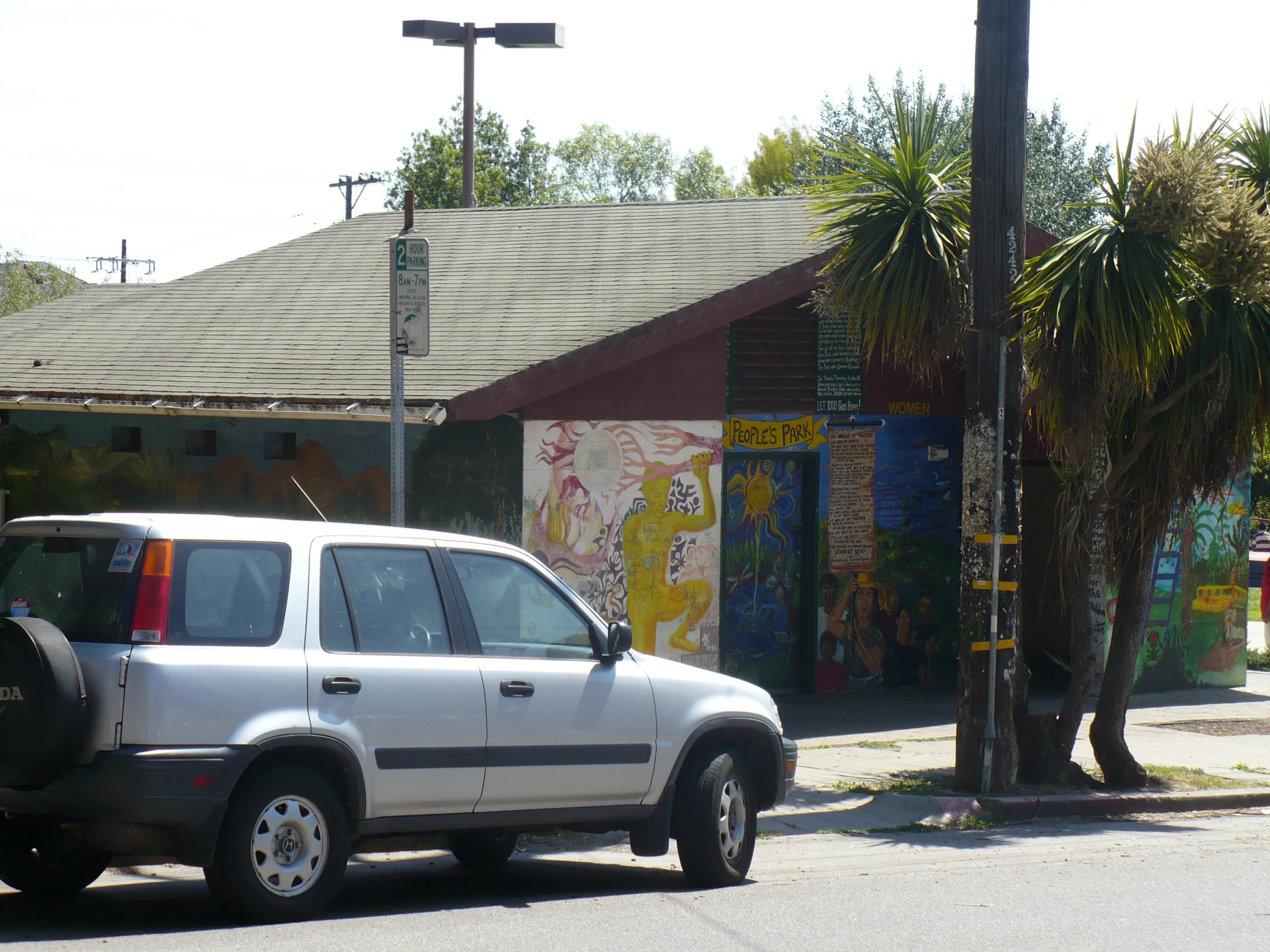 white four door suv parked next to street with palm trees