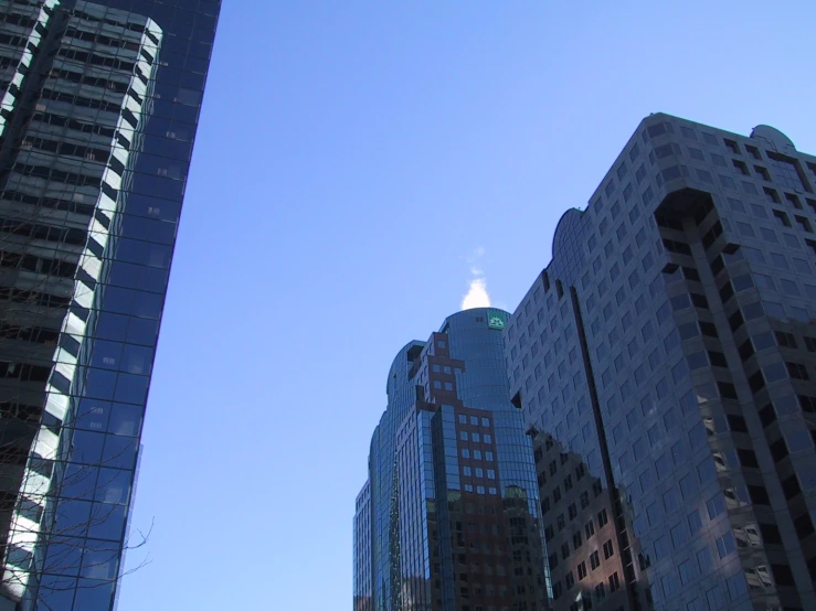 a view of skyscrs from the ground looking up