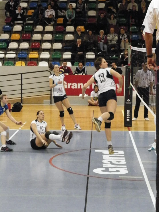 four female volleyball players are playing ball on a court
