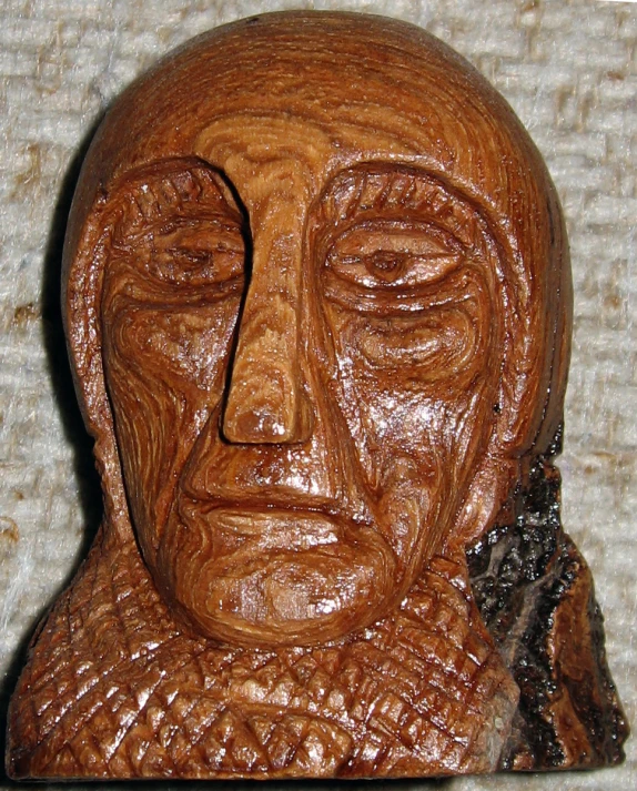 a carved wooden head has a beard