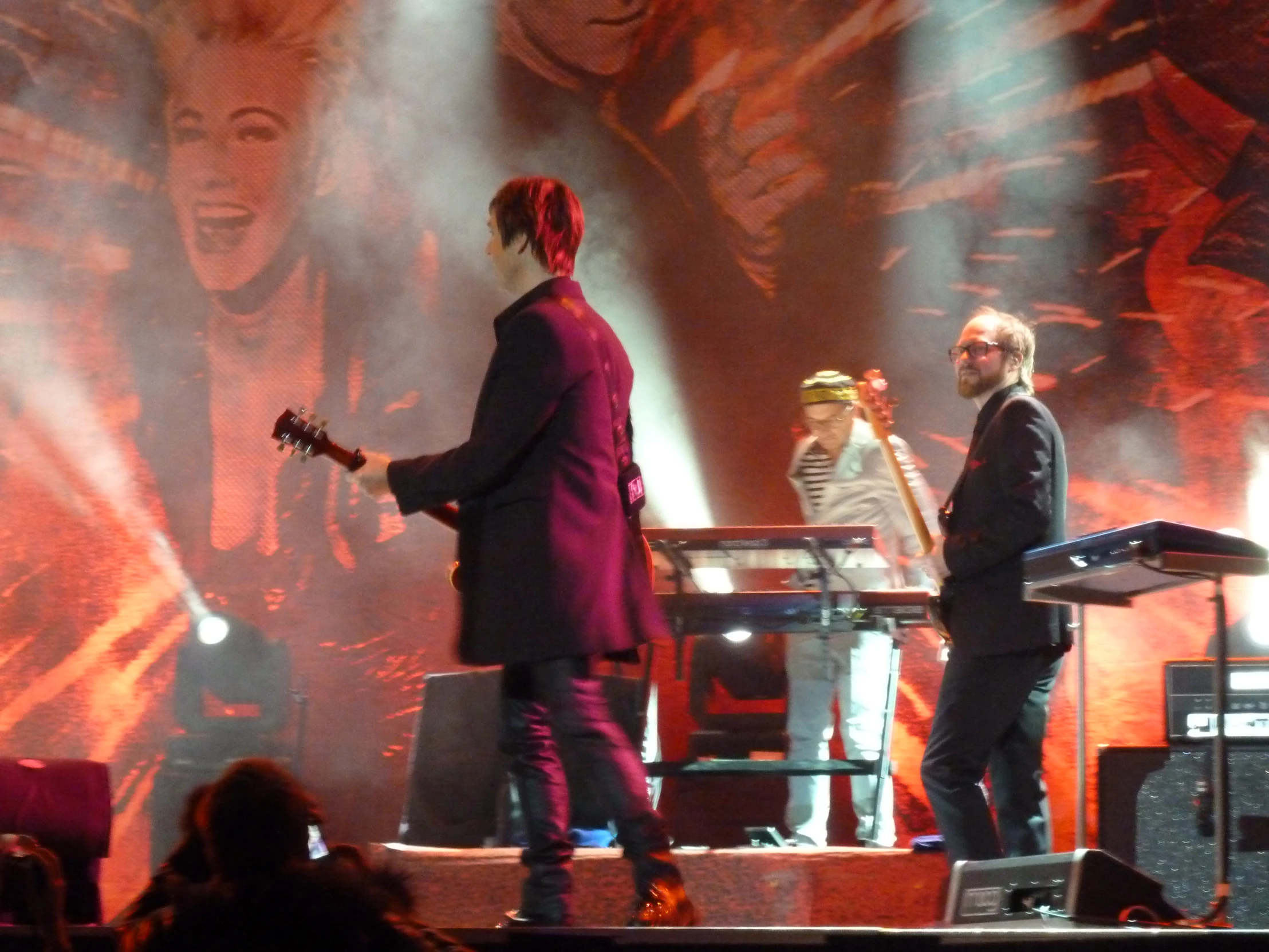 three people on stage at a concert