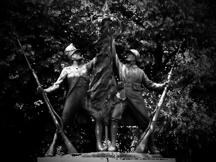 three statues holding rifles in front of some trees