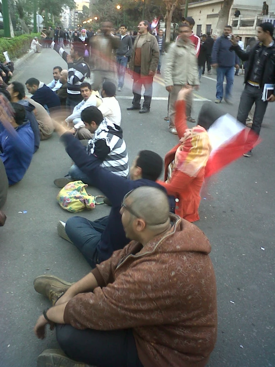 a group of people sitting on the road