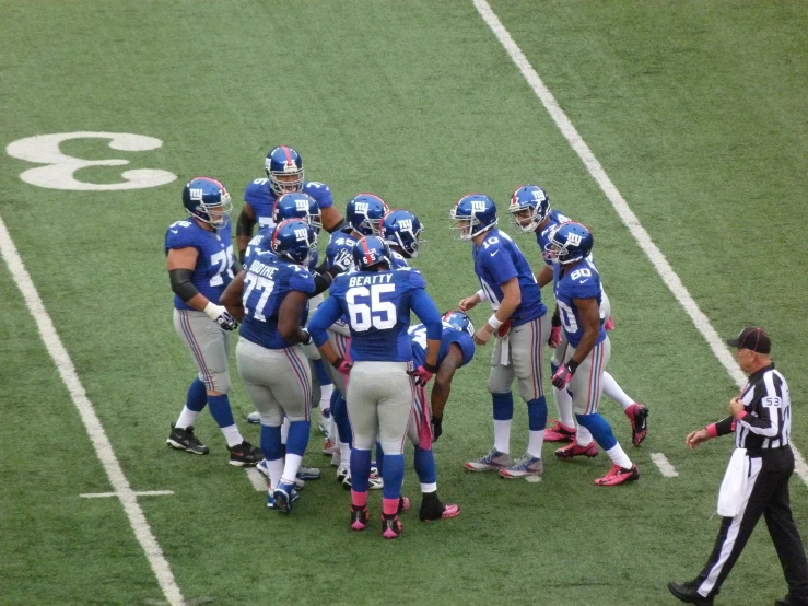 football players standing on the field with an referee