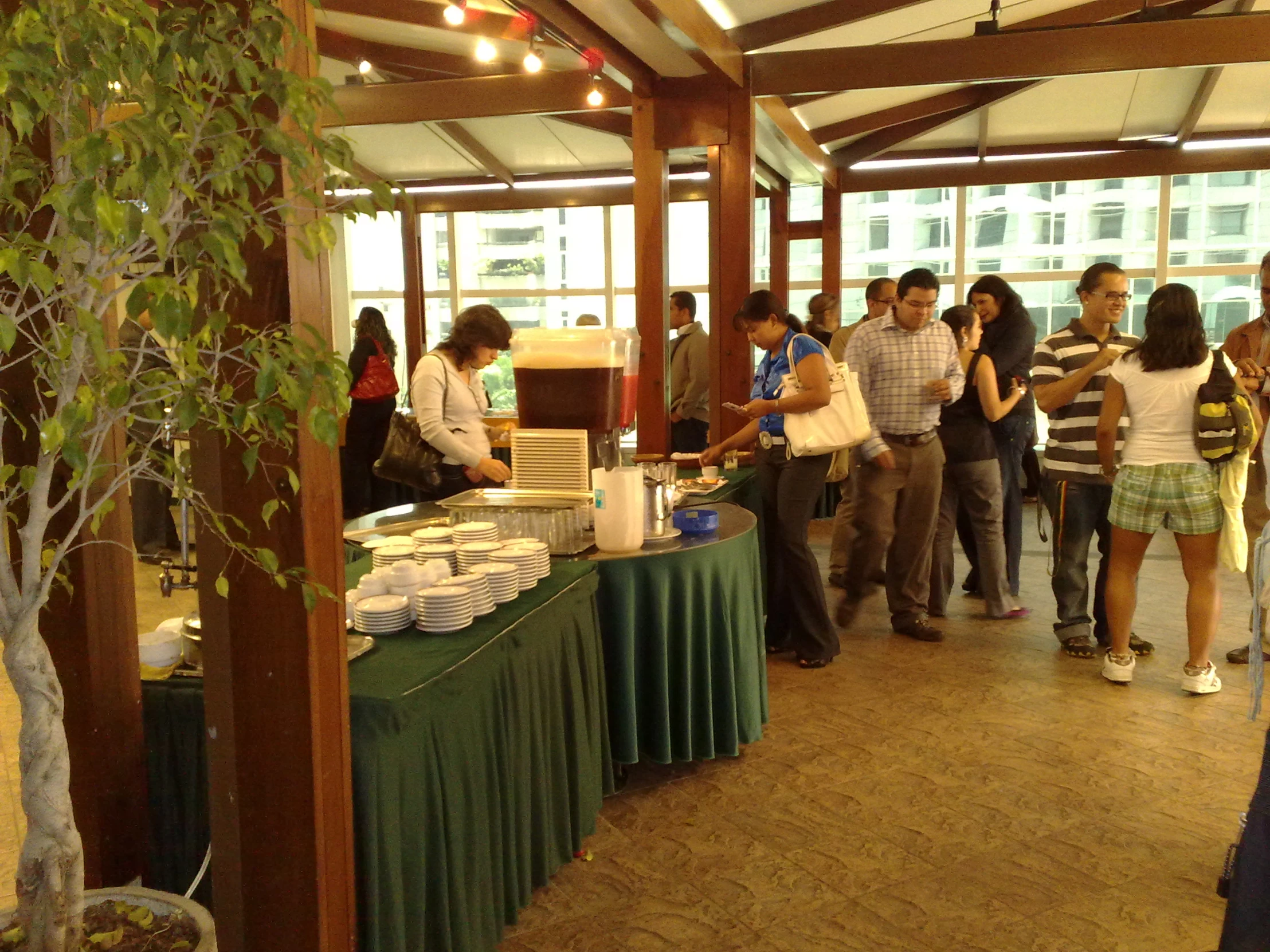 many people are standing around a booth at a market