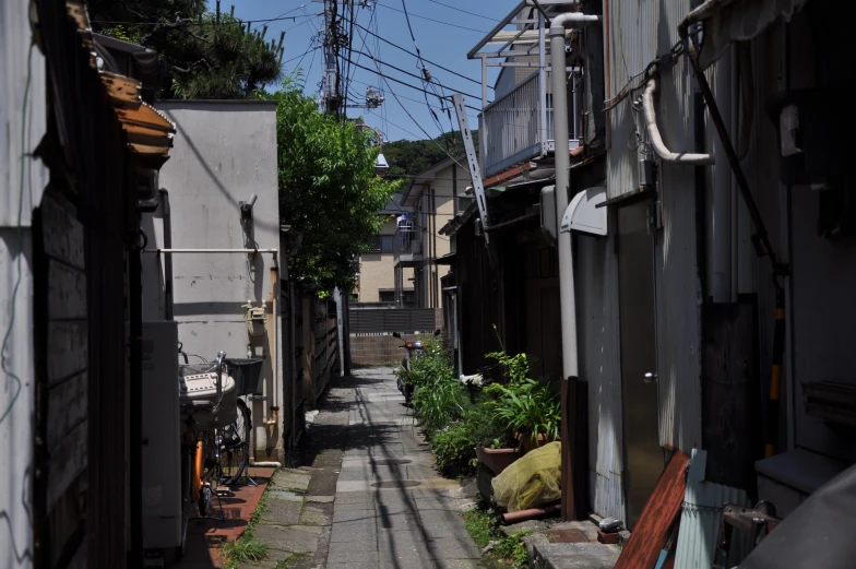 a narrow city street with power lines and buildings