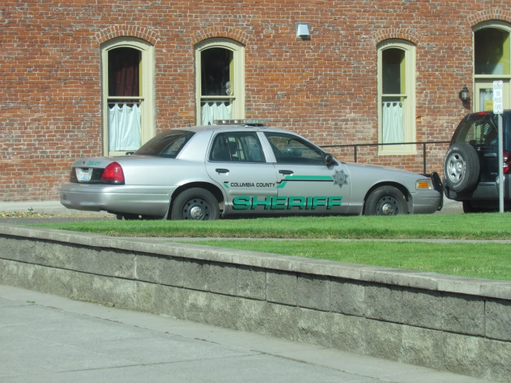 a car parked in front of an old brick building