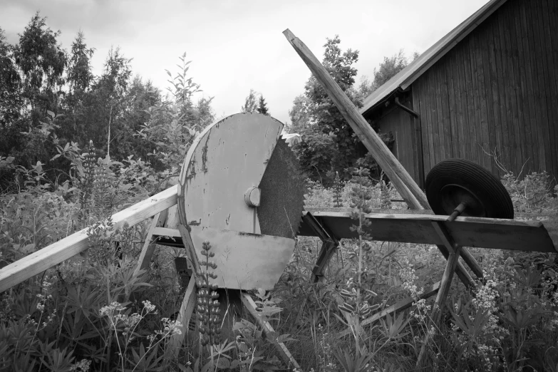 the abandoned wheel of an old truck stands in the woods