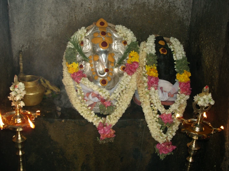 flowers and candles with an idol near by