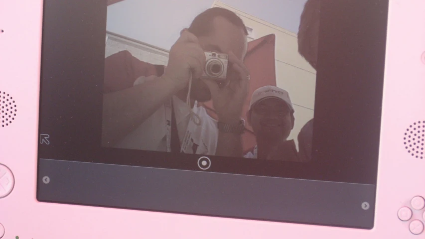 a person taking a po of themselves in front of a pink wall