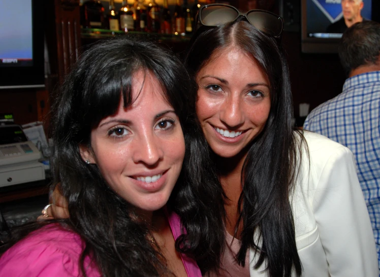 two beautiful women standing next to each other at a party