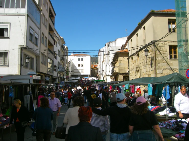 a crowd is walking through a crowded market street