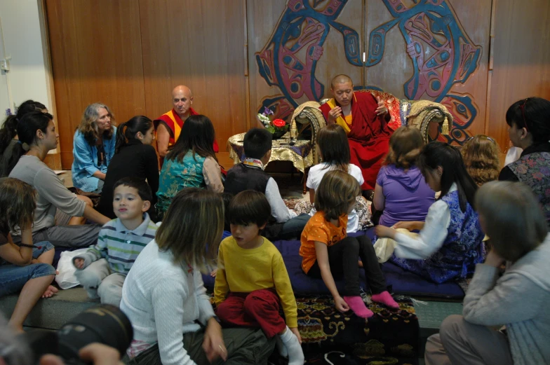 there is a large group of people that are sitting on the floor