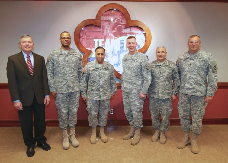 two men standing next to seven other men in uniform