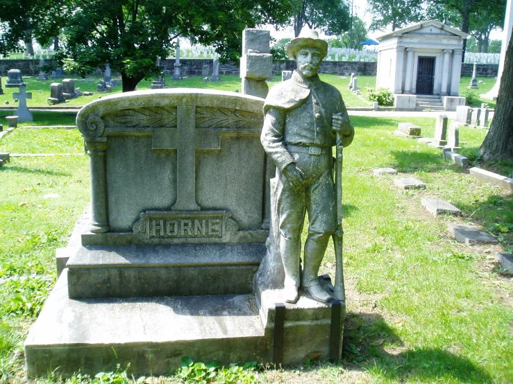 a statue in a cemetery on top of some grass