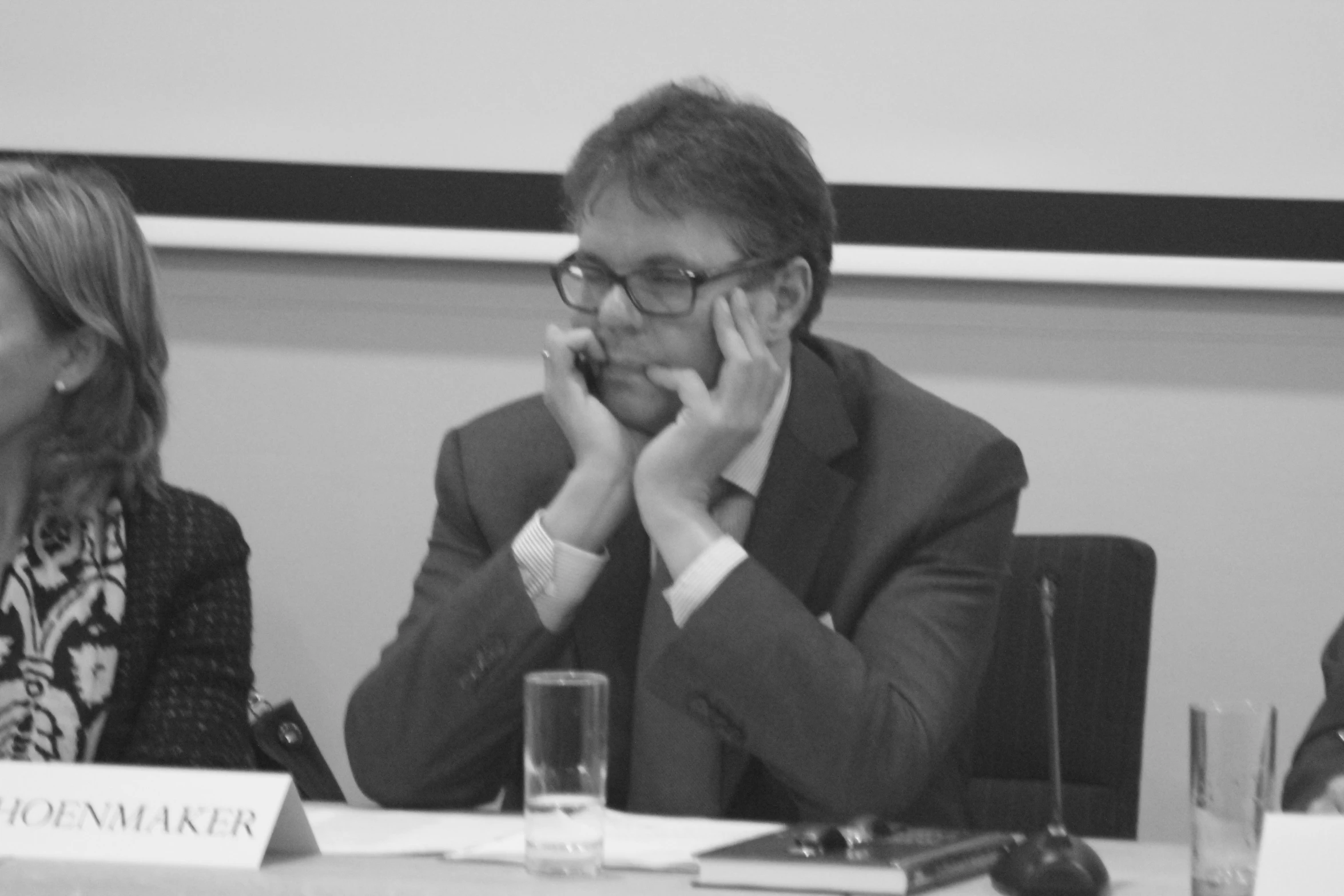 a man is sitting next to a woman in front of the conference room