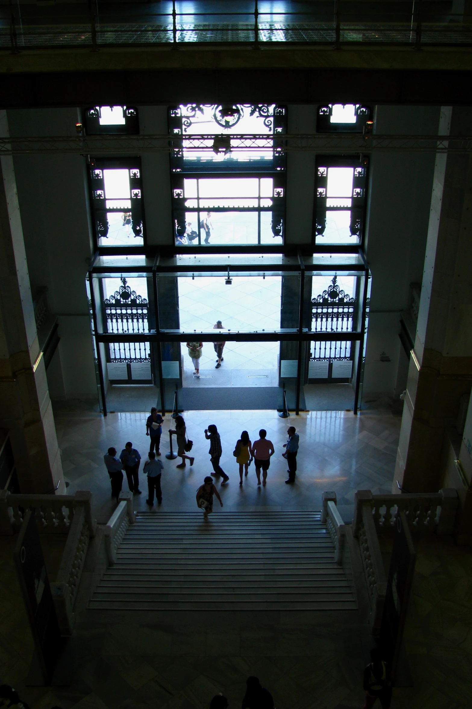 people standing in a building with large windows