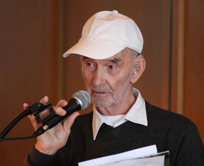 an old man is giving a speech at a press conference