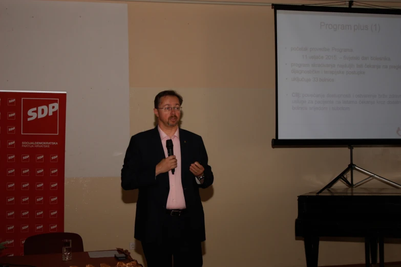 a man standing in front of a podium giving a presentation