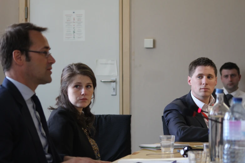 four people are sitting down to a meeting