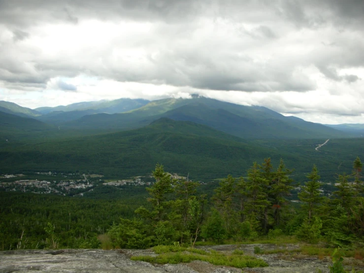 a view of the mountains in the distance with cloudy skies above