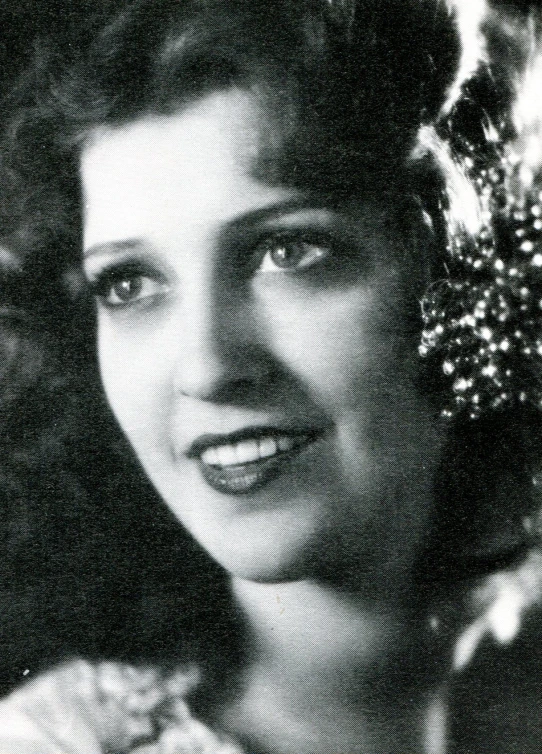 a vintage pograph shows an older woman with flowers in her hair