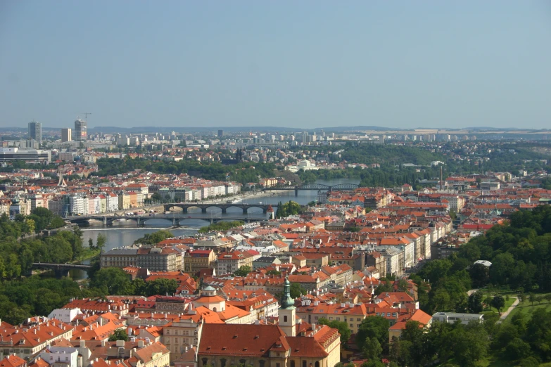 city view of a town with red roofs and large river in the background